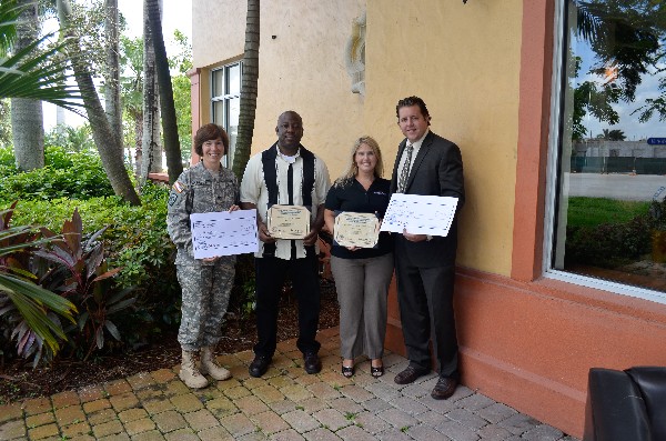In November, Col. Maria Barrett, USA, chapter president, and Bill Lawless (r), chapter scholarships chairman, present two science, technology, engineering and mathematics grants to Carissa Brazeal, Hollywood Academy of Arts and Science, and Manuel Cox, American High School.